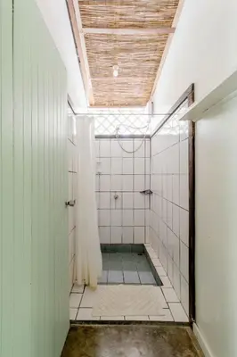 a bathroom with a shower with white tiled walls at Bajo el Arbol B&B in Santa Teresa Beach