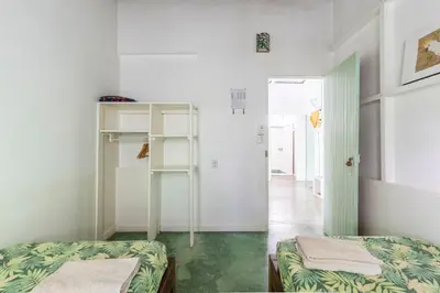 a room with two beds and a hallway at Bajo el Arbol B&B in Santa Teresa Beach