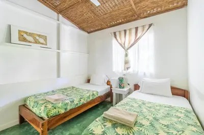 a bedroom with two beds and a window at Bajo el Arbol B&B in Santa Teresa Beach
