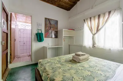 a bedroom with a bed and a window at Bajo el Arbol B&B in Santa Teresa Beach