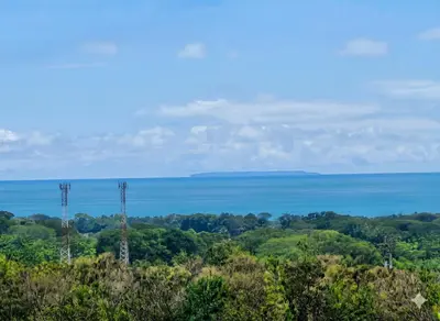 a view of the ocean from a hill with two electricity towers at Uvita, Bahía Ballena, Ocean View in Uvita