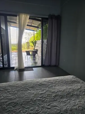 a bedroom with a bed and a sliding glass door at Uvita, Bahía Ballena, Ocean View in Uvita