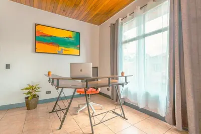 a desk with a laptop in a room with a window at Gray Oasis, Private Pool in Agua Azul
