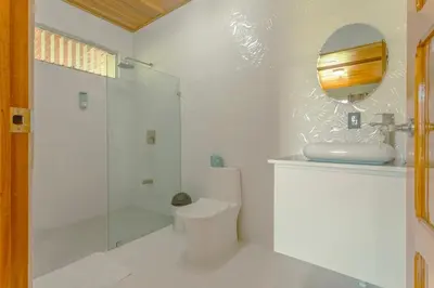 a white bathroom with a toilet and a shower at Gray Oasis, Private Pool in Agua Azul