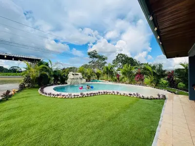 a swimming pool in a grassy yard with people in it at Gray Oasis, Private Pool in Agua Azul