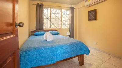 a bedroom with a bed with a blue blanket and a window at Fortuna Flat Walk & Value in Fortuna