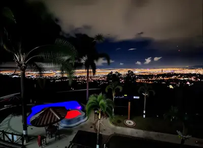 a view of a city at night with palm trees at Casa Escazu Overlook in San Antonio
