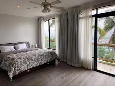 a bedroom with a bed and a large window at Casa Escazu Overlook in San Antonio