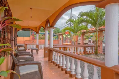a balcony of a resort with chairs and palm trees at Oasis 17 , Group Getaway in Fortuna
