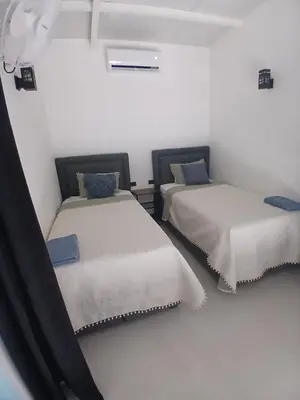 two beds in a room with white walls at Loft en San José de pinilla avellanas guanacaste in San José Pinilla