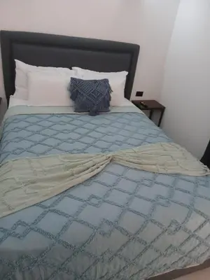 a bed with a blue comforter and pillows on it at Loft en San José de pinilla avellanas guanacaste in San José Pinilla