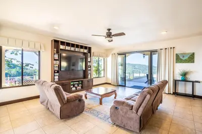 a living room with two chairs and a tv at Luxury Villa Bijagual Costa Rica in Carara