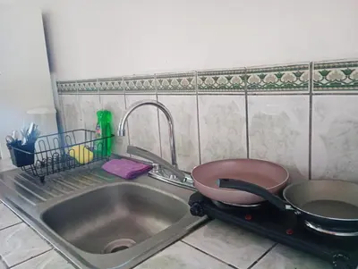 a kitchen sink with a pot and a strainer at Cabaña cielo celeste in Rio Celeste