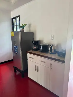 a kitchen with a refrigerator and a red floor at Cabaña cielo celeste in Rio Celeste