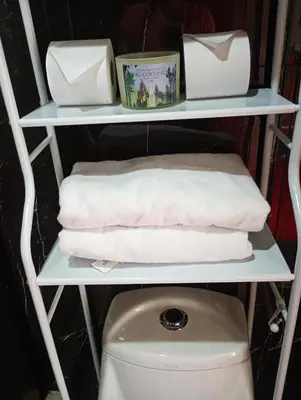 a shelf with towels and a toilet in a bathroom at Cabaña cielo celeste in Rio Celeste