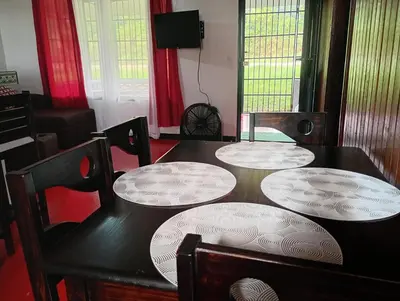a dining room with a table and four chairs at Cabaña cielo celeste in Rio Celeste