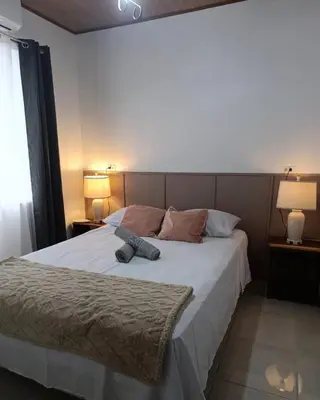 a bedroom with a large white bed with two lamps at Coral House Fortuna in Tanque