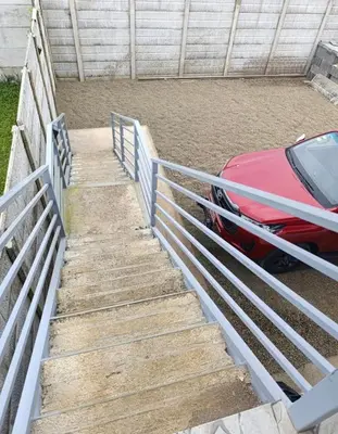 a red car parked next to a metal fence at Coral House Fortuna in Tanque