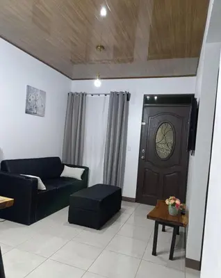 a living room with a couch and a clock on the door at Coral House Fortuna in Tanque