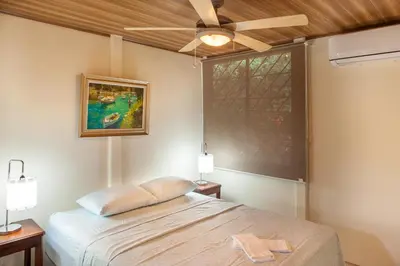 a bedroom with a bed and a ceiling fan at Nosara Beach Cabins in Nicoya