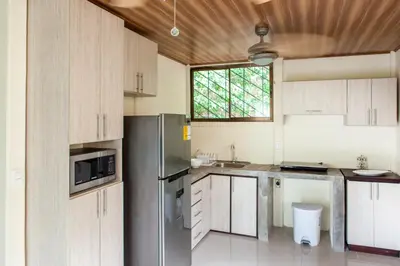 a kitchen with a stainless steel refrigerator and a window at Nosara Beach Cabins in Nicoya