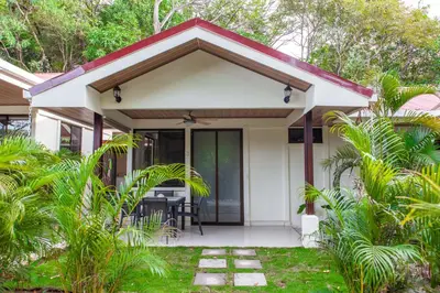 a small white house with a red roof at Nosara Beach Cabins in Nicoya