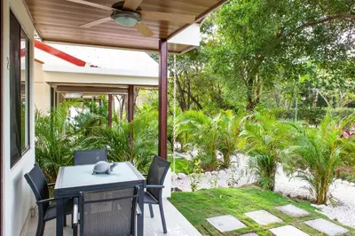a patio with a table and chairs on a porch at Nosara Beach Cabins in Nicoya