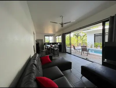 a living room with a couch and a pool at Casa Cascada La Roca in Sámara