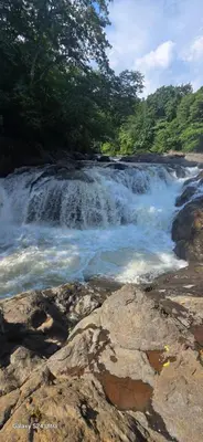 a waterfall on a river with rocks and trees at Casa Cascada La Roca in Sámara