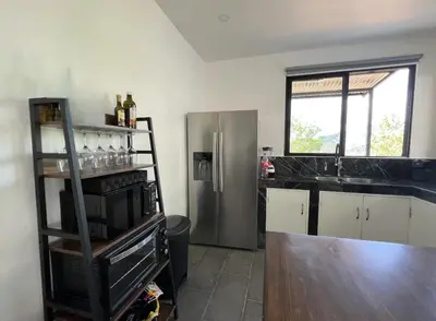 a kitchen with a stainless steel refrigerator and a counter at Casa Cascada La Roca in Sámara