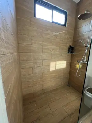a bathroom with a shower with wooden walls and a window at Casa Cascada La Roca in Sámara