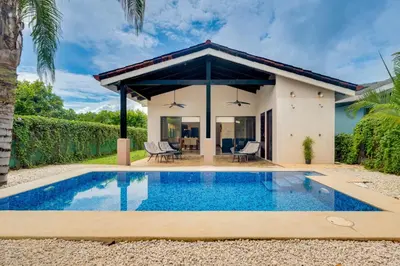 a villa with a swimming pool and a house at Casa Fabali in Tamarindo