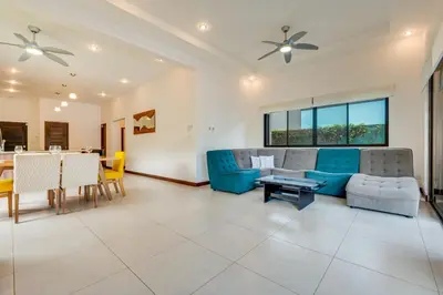 a living room with a blue couch and a table at Casa Fabali in Tamarindo