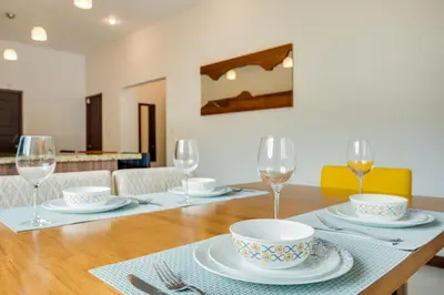a wooden table with plates and glasses on it at Casa Fabali in Tamarindo