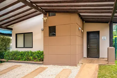 a home with a brown door and a wooden ceiling at Casa Fabali in Tamarindo