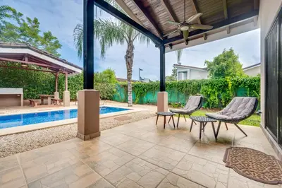 an outdoor patio with two chairs and a pool at Casa Fabali in Tamarindo