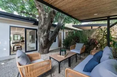 a patio with couches and a table and a tree at Luxury 2BR Villa by Tamarindo, AC, Private Yard in Tamarindo