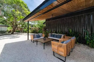 a patio with couches and a table and a building at Luxury 2BR Villa by Tamarindo, AC, Private Yard in Tamarindo