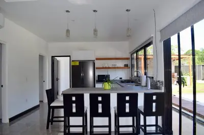 a kitchen with a large island with chairs in it at CASA CEA-Swimming Pool Rancho SantaTeresa Malpais in San Isidro