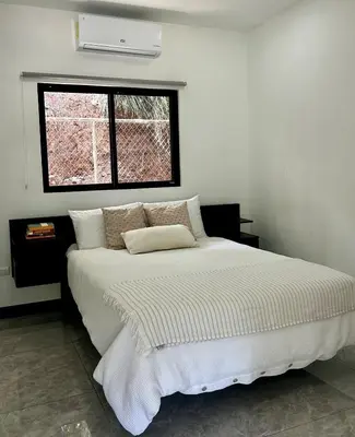 a bedroom with a white bed with a window at CASA CEA-Swimming Pool Rancho SantaTeresa Malpais in San Isidro
