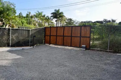 a fence with a large wooden gate and a gate at CASA CEA-Swimming Pool Rancho SantaTeresa Malpais in San Isidro