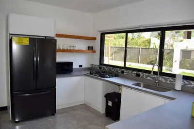 a kitchen with a black refrigerator and a sink at CASA CEA-Swimming Pool Rancho SantaTeresa Malpais in San Isidro