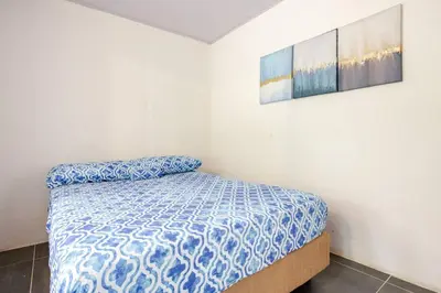 a small bedroom with a bed and a painting on the wall at Private Costa Rican Oasis with Pool River Views in Cóbano