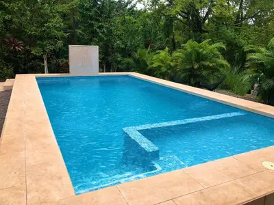 a swimming pool with blue water in a yard at Private Costa Rican Oasis with Pool River Views in Cóbano