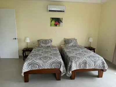 a bedroom with two beds and two lamps at In the Heart of Nature in Tarcoles