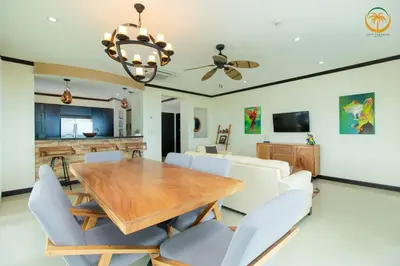 a dining room with a wooden table and chairs at Modern Condominium Beachfront Jaco Beach, Diamante del Sol in Jacó