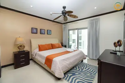 a bedroom with a bed and a ceiling fan at Modern Condominium Beachfront Jaco Beach, Diamante del Sol in Jacó