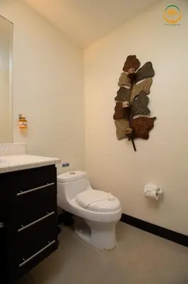 a bathroom with a toilet and a shelf on the wall at Modern Condominium Beachfront Jaco Beach, Diamante del Sol in Jacó