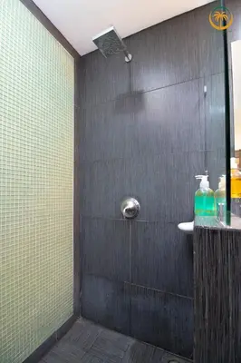 a bathroom with a shower with a sink at Modern Condominium Beachfront Jaco Beach, Diamante del Sol in Jacó