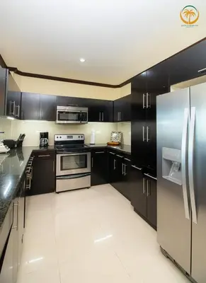 a kitchen with black cabinets and stainless steel appliances at Modern Condominium Beachfront Jaco Beach, Diamante del Sol in Jacó
